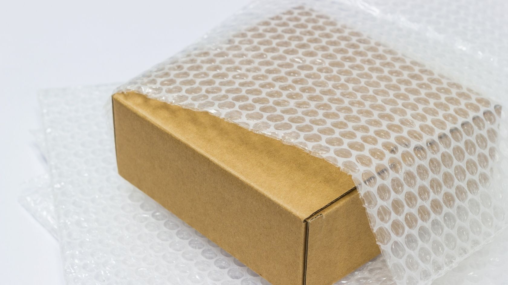 Cardboard parcel wrapped in plastic packaging showing materials affected by EPR