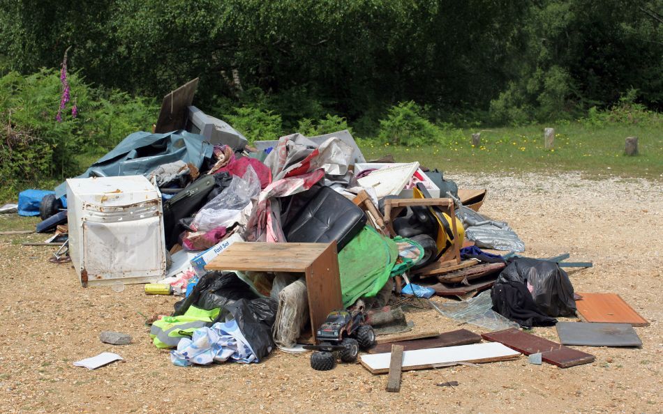 Illegal fly-tipped waste dumped in a rural UK area, highlighting the growing issue of waste crime and lack of enforcement.